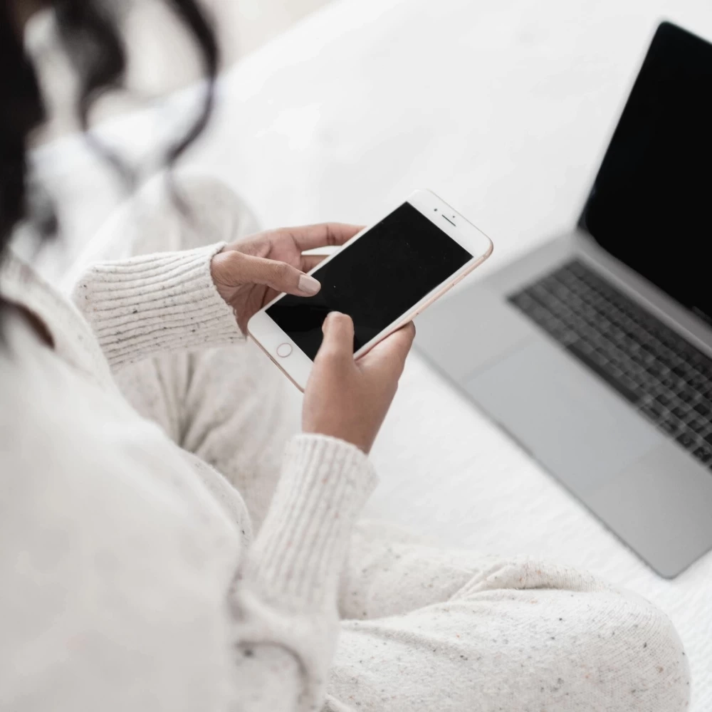 female blogger sitting on best holding phone