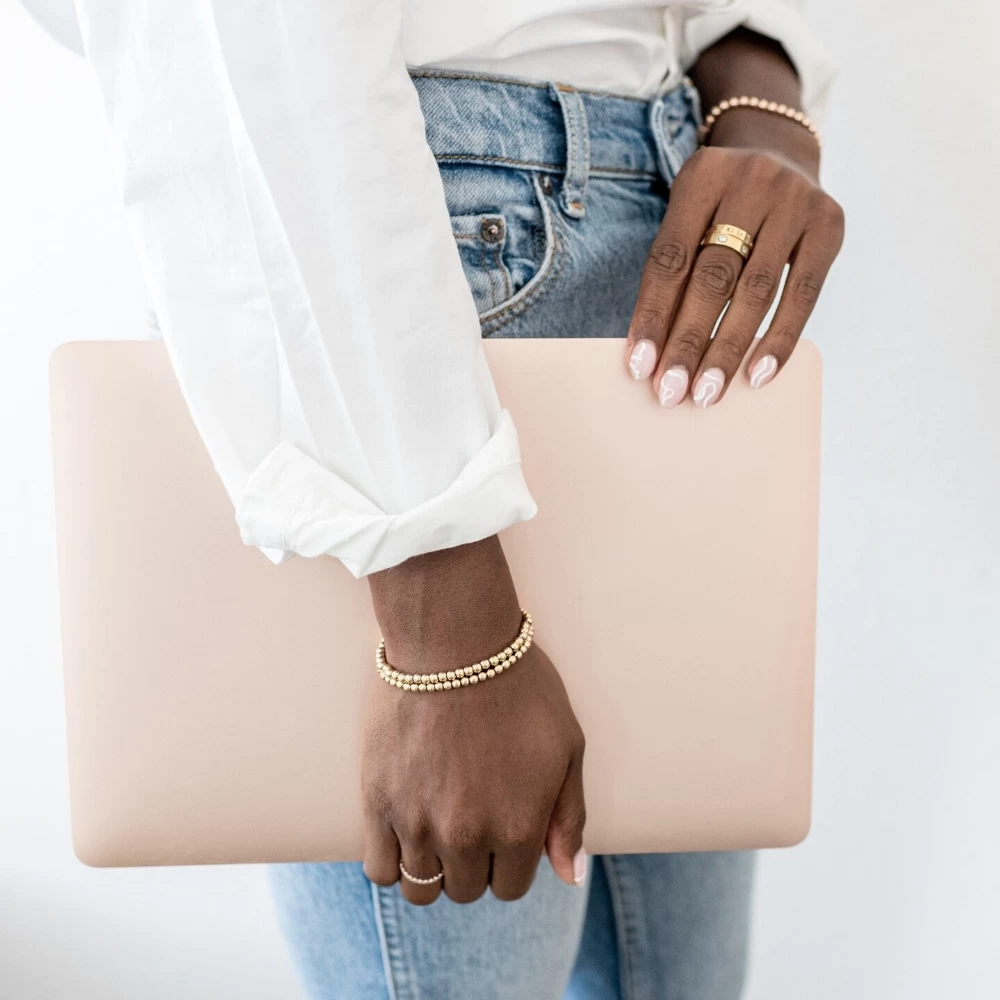 how to easily find the best canva stock photos 1 lady in jeans and white shirt holding rose gold laptop