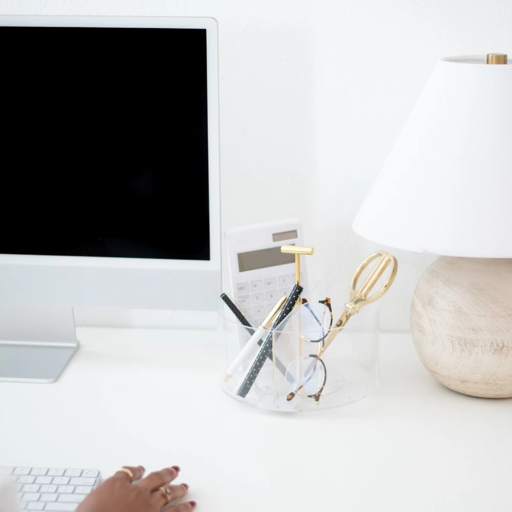 iMac on desk with brown lamp and desk accessories