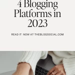 woman in white sweater and gold rings typing on laptop