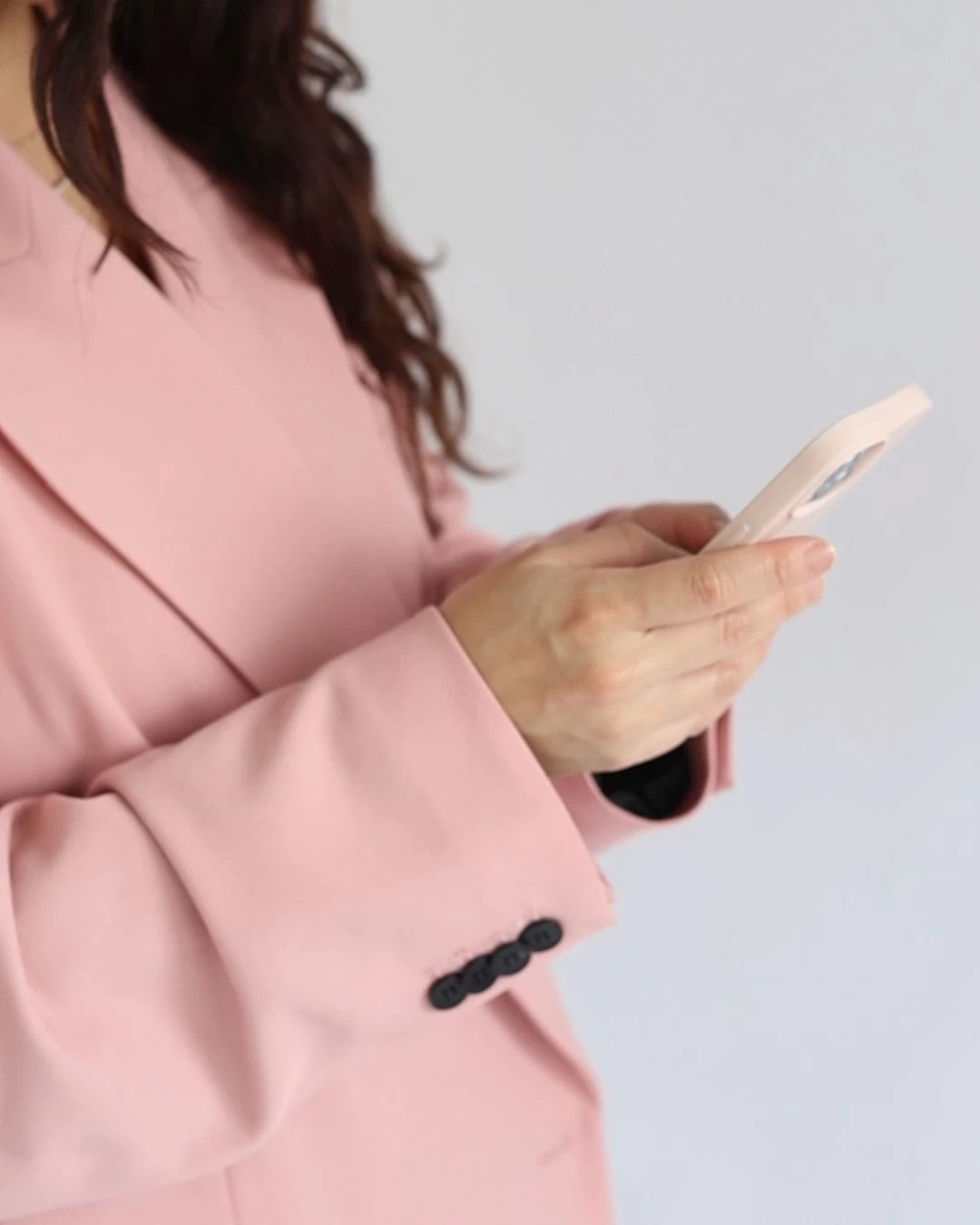 female creator in pink scrolling through phone