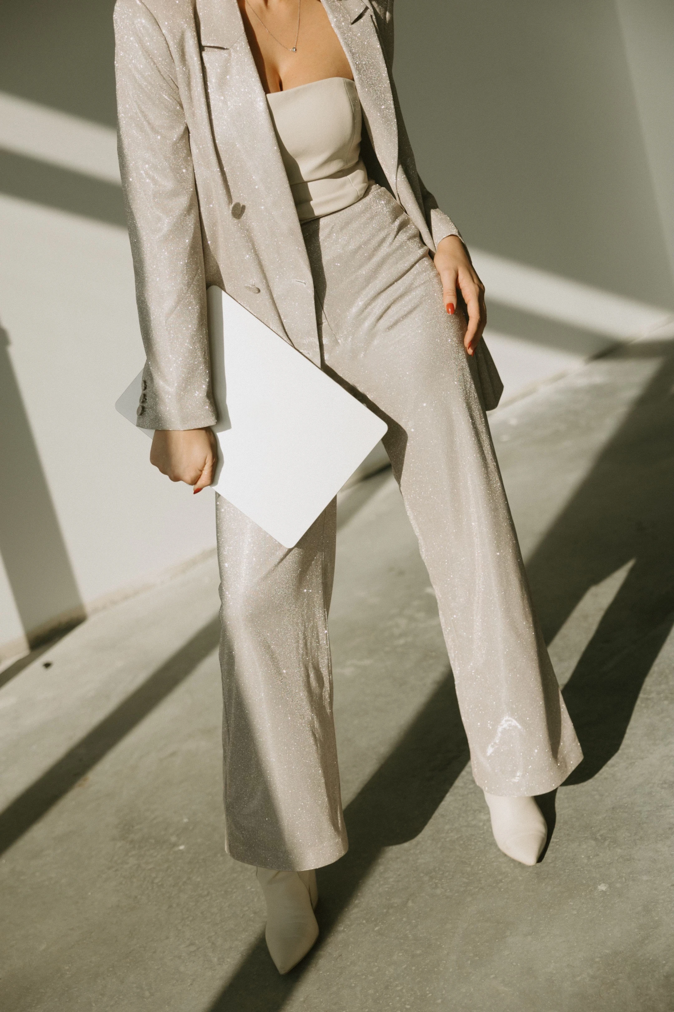 woman in suit holding laptop