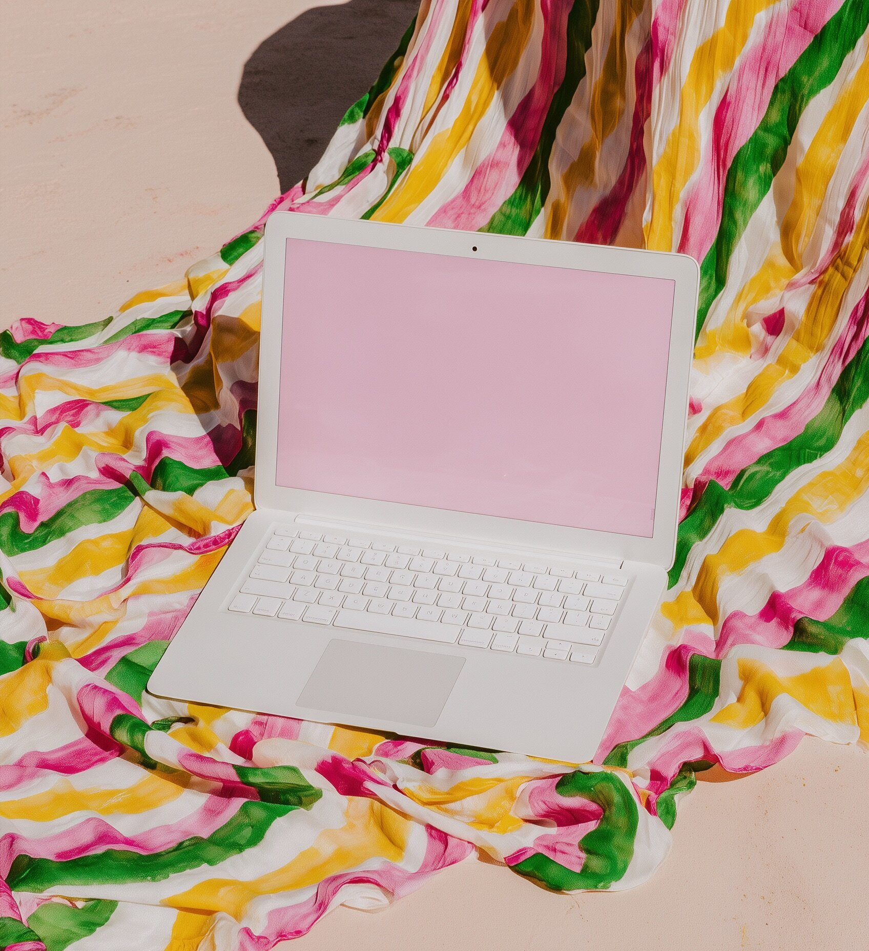 Pink laptop on a desk for a blogging workspace setup
